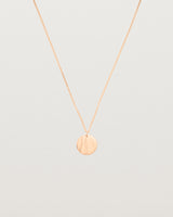 An engraved rose gold pendant