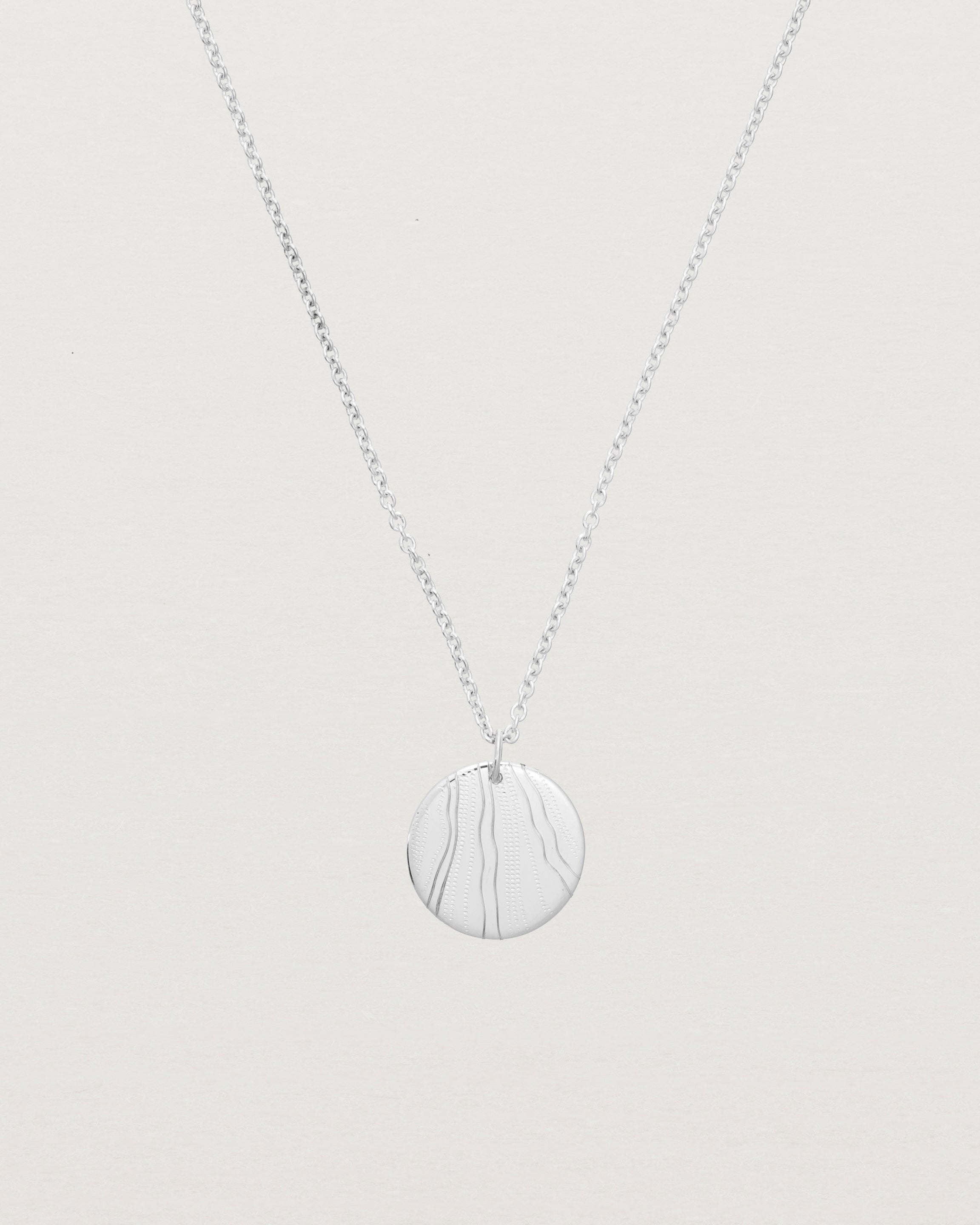 An engraved sterling silver pendant