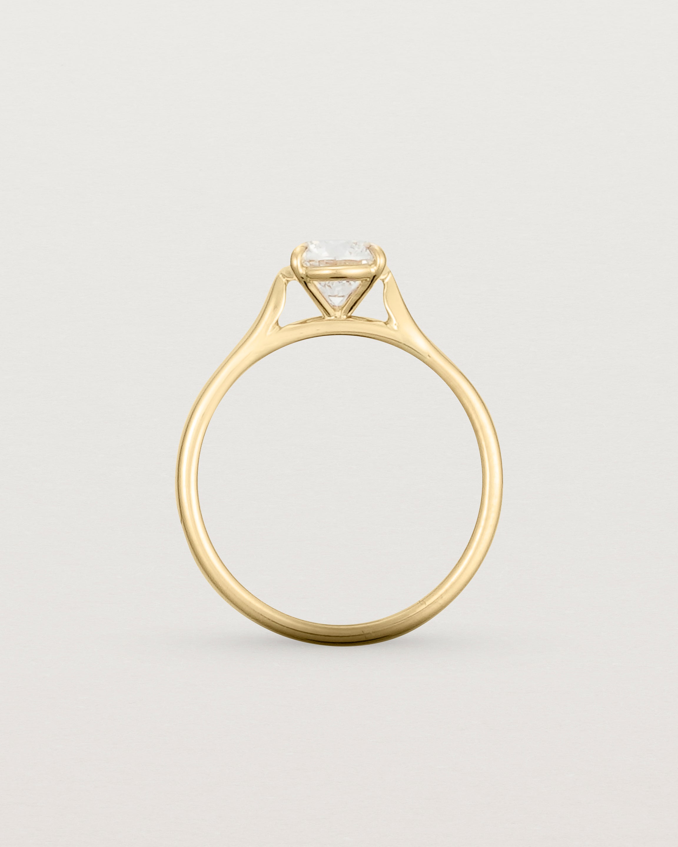 Side profile of a 0.90ct round white diamond, adorns a 1.6mm half round 18ct Yellow Gold band.