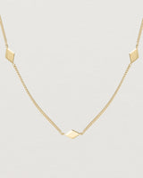 Close up view of the Nuna Charm Necklace in yellow gold.
