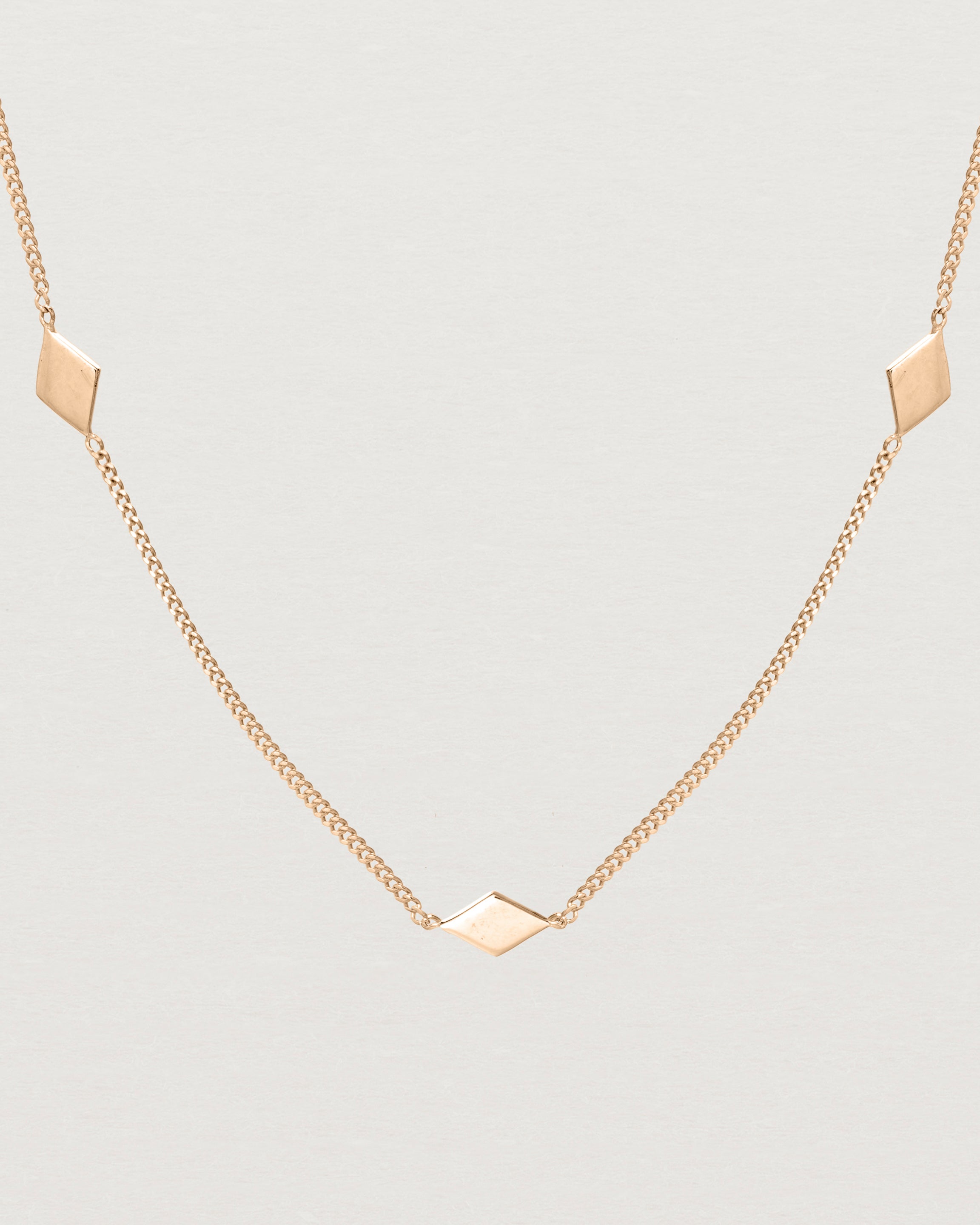 Close up view of the Nuna Charm Necklace in rose gold.