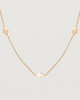 Close up view of the Nuna Charm Necklace in rose gold.