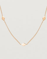 Close up view of the Nuna Charm Necklace in rose gold.