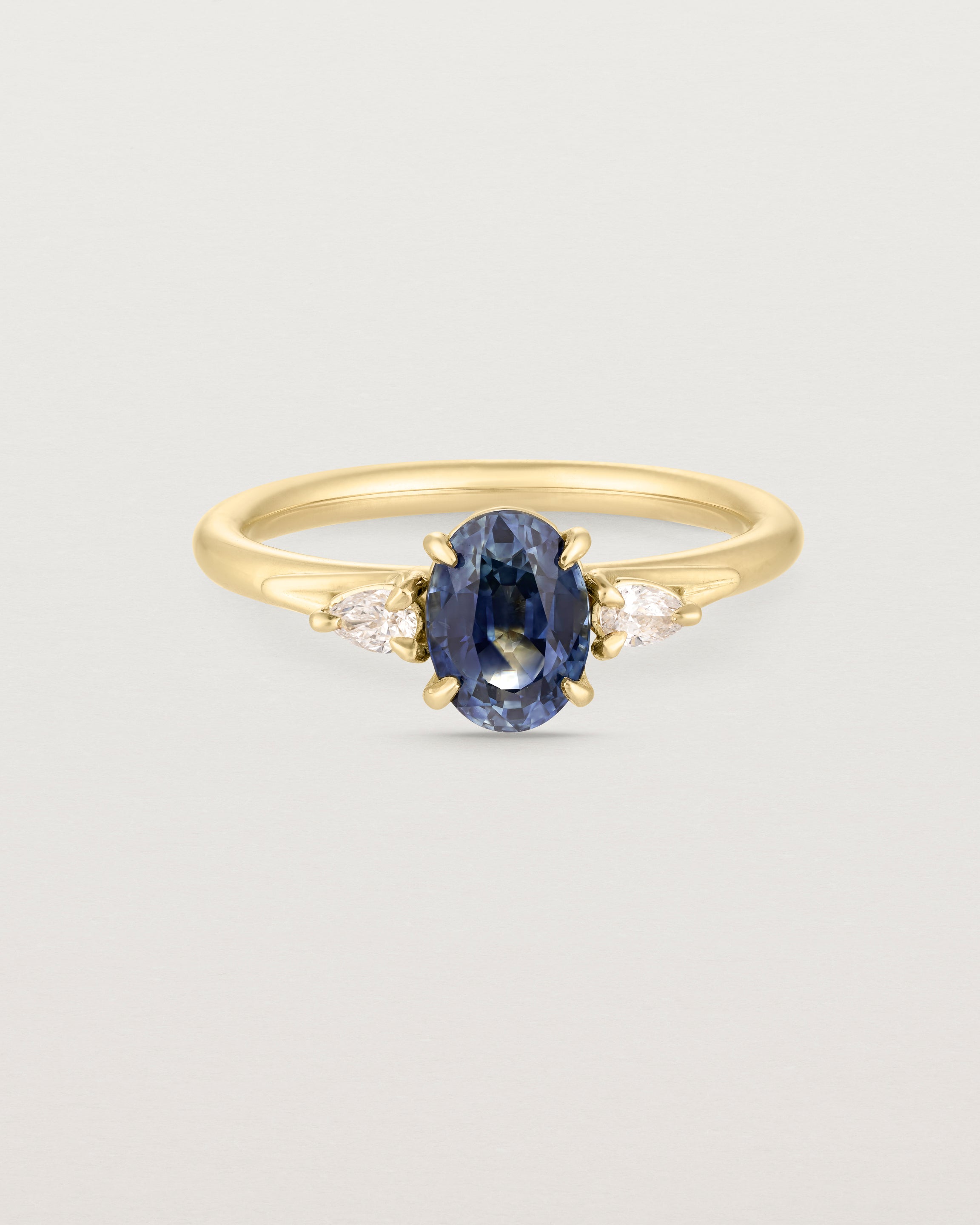 Front image of blue sapphire trio ring with white diamonds.