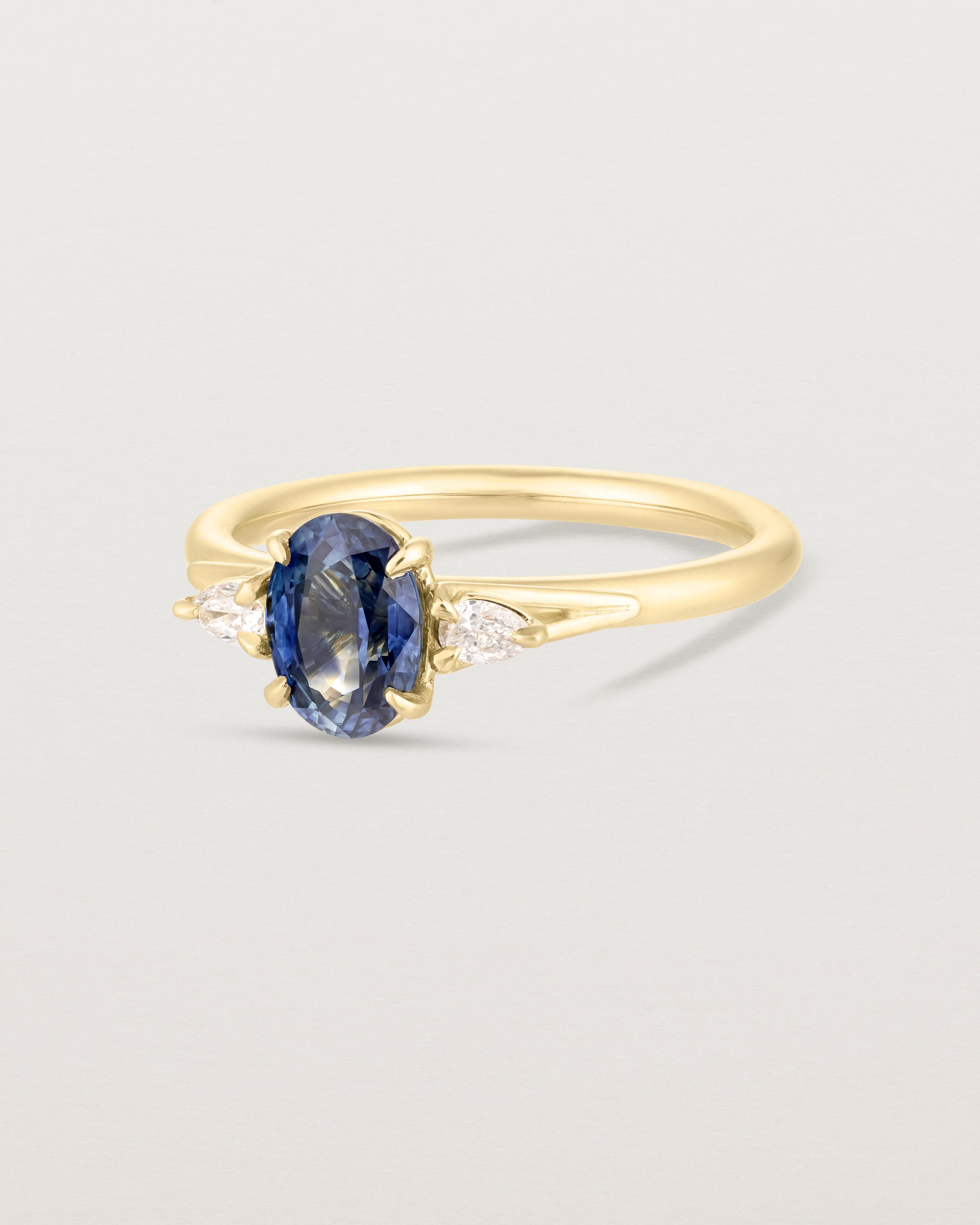 Front image of blue sapphire trio ring with white diamonds.