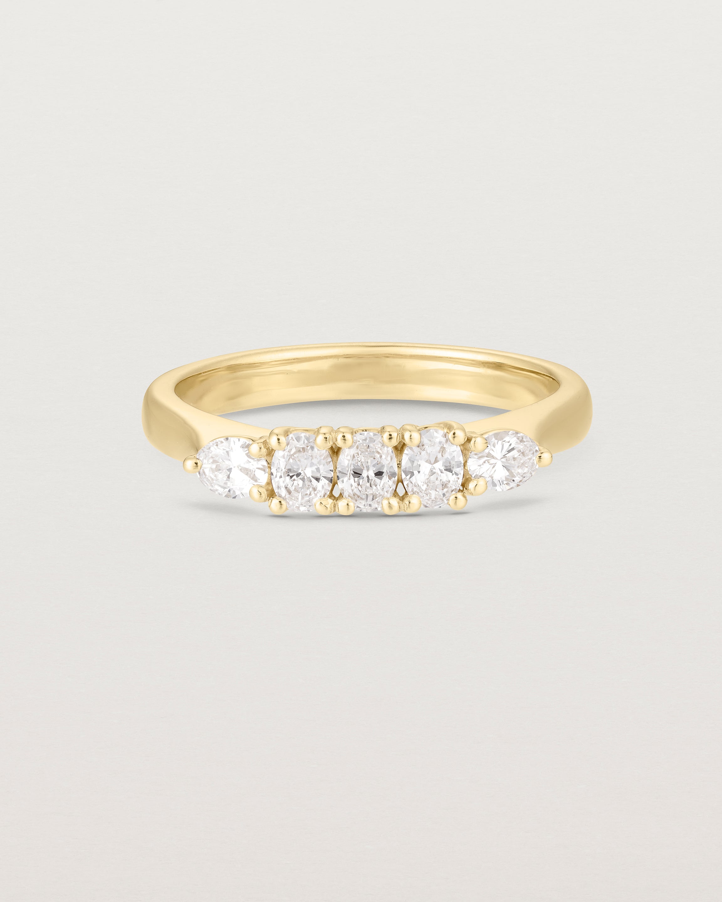 Front on image of diamond engagement ring in yellow gold. Featuring five white diamonds.