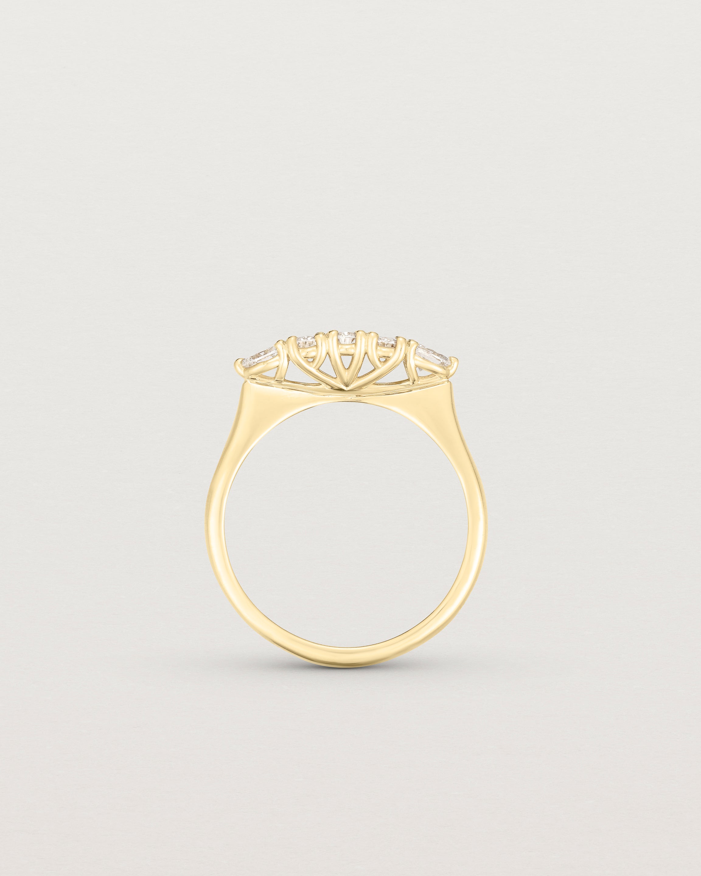 Standing image of diamond engagement ring in yellow gold. Featuring five white diamonds.