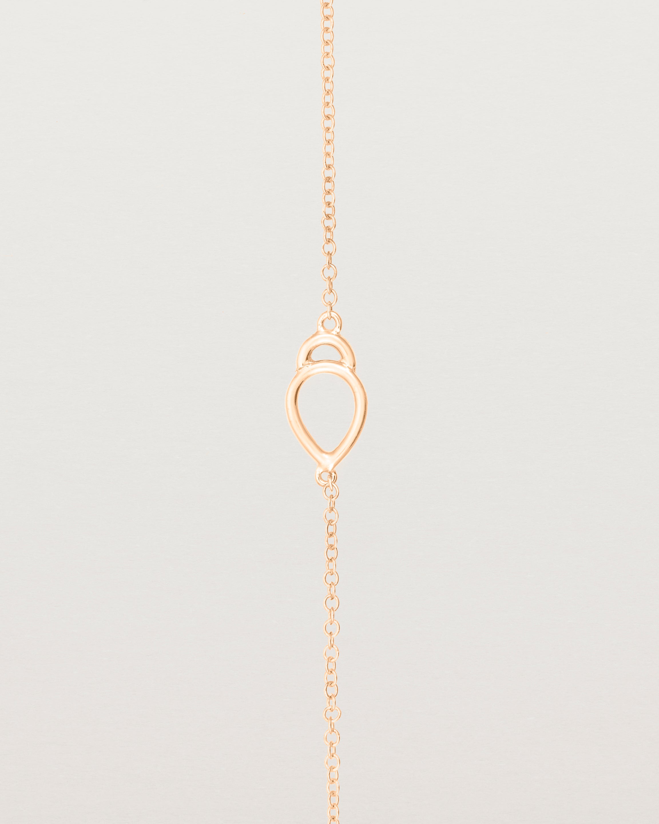 A rose gold chain with an oval pendant