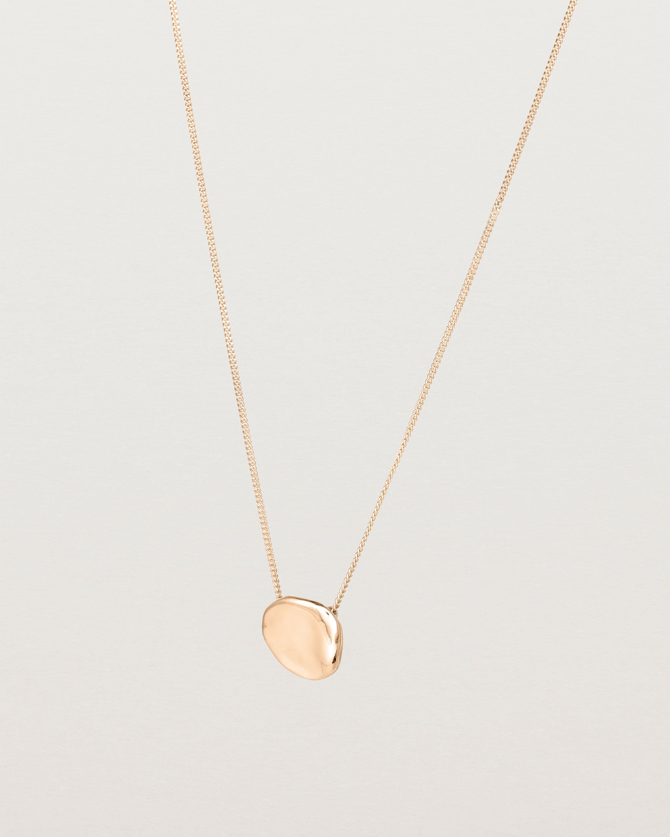 Angled view of the Petite Mana Necklace in rose gold.