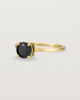 Angled view of the Petite Una Round Solitaire | Black Spinel | Yellow Gold.