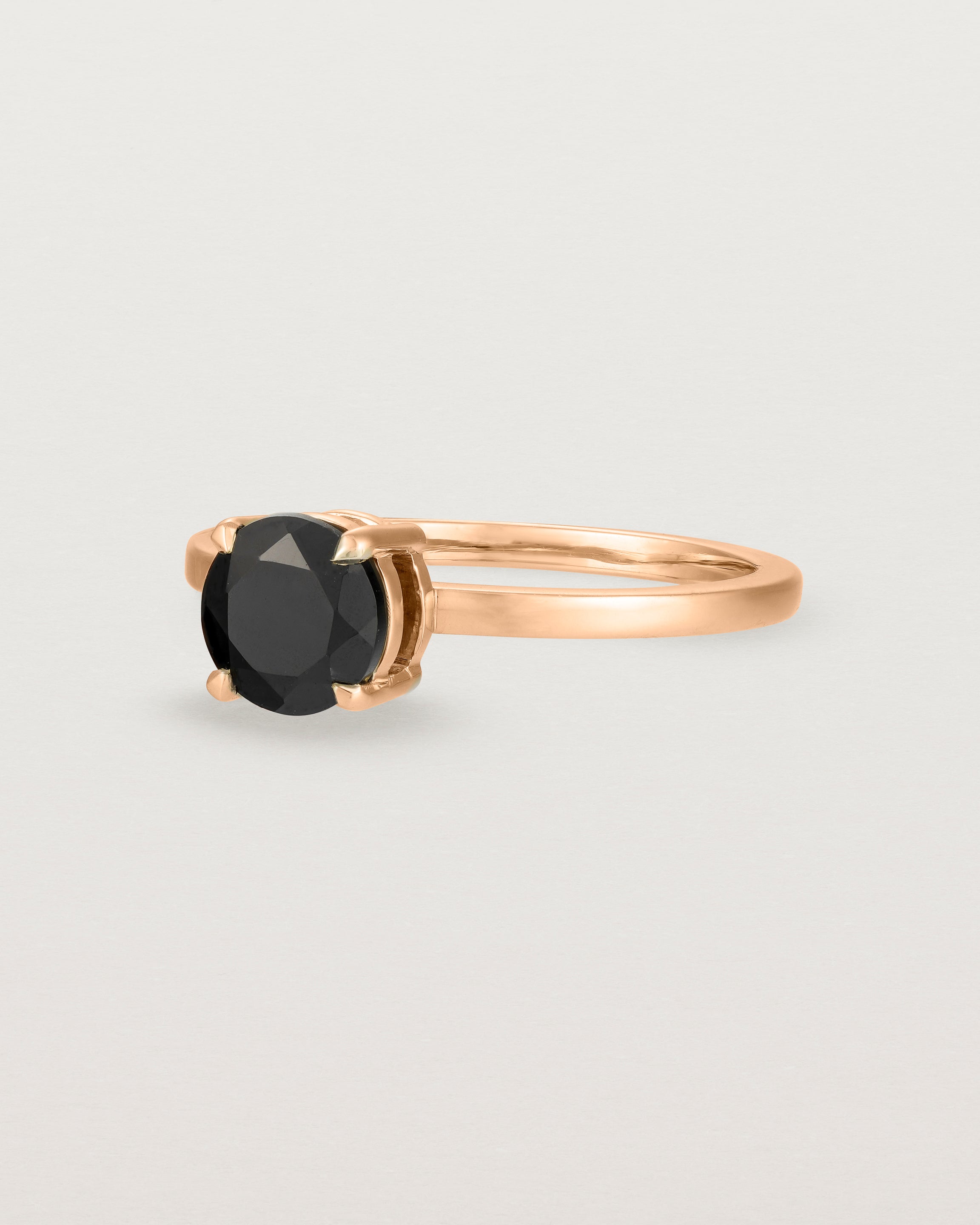Angled view of the Petite Una Round Solitaire | Black Spinel | Rose Gold.