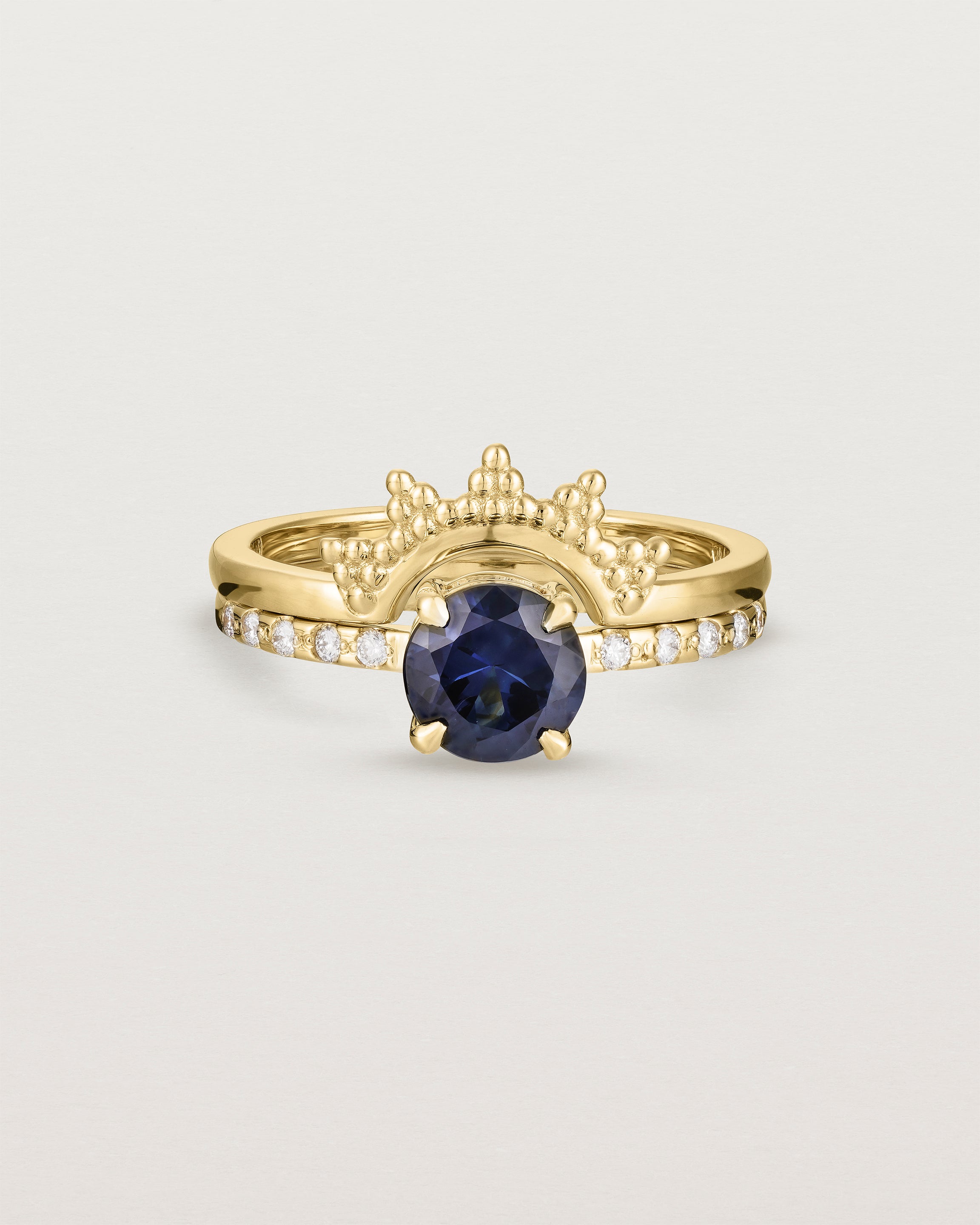 Front view of the Petite Una Round Solitaire | Australian Sapphire | Yellow Gold with cascade shoulders stacked with the Odine Crown Ring.  