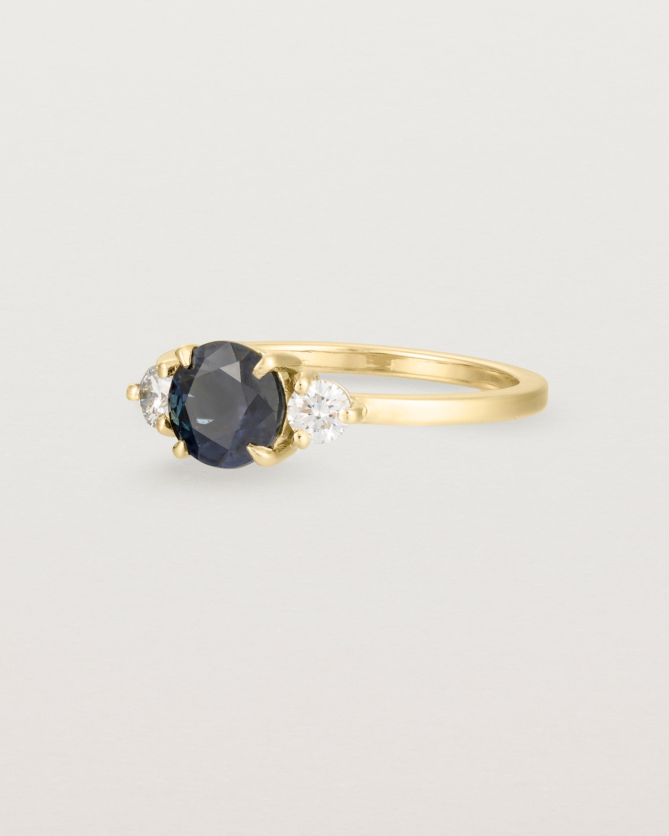 Angled view of the Petite Una Round Trio Ring | Australian Sapphire & Diamonds | Yellow Gold.