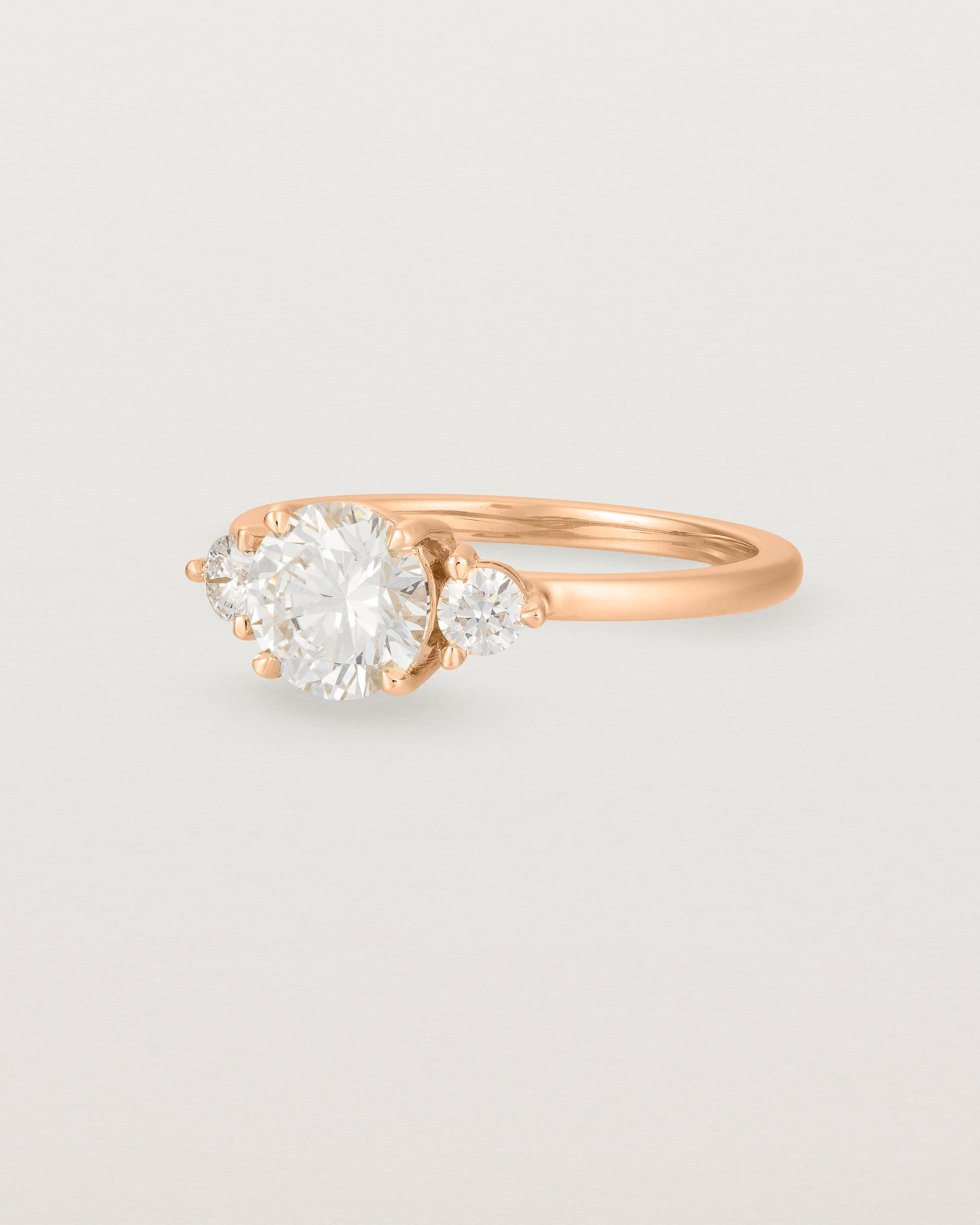 Angled view of the Petite Una Round Trio Ring | Laboratory Grown Diamonds | Rose Gold.