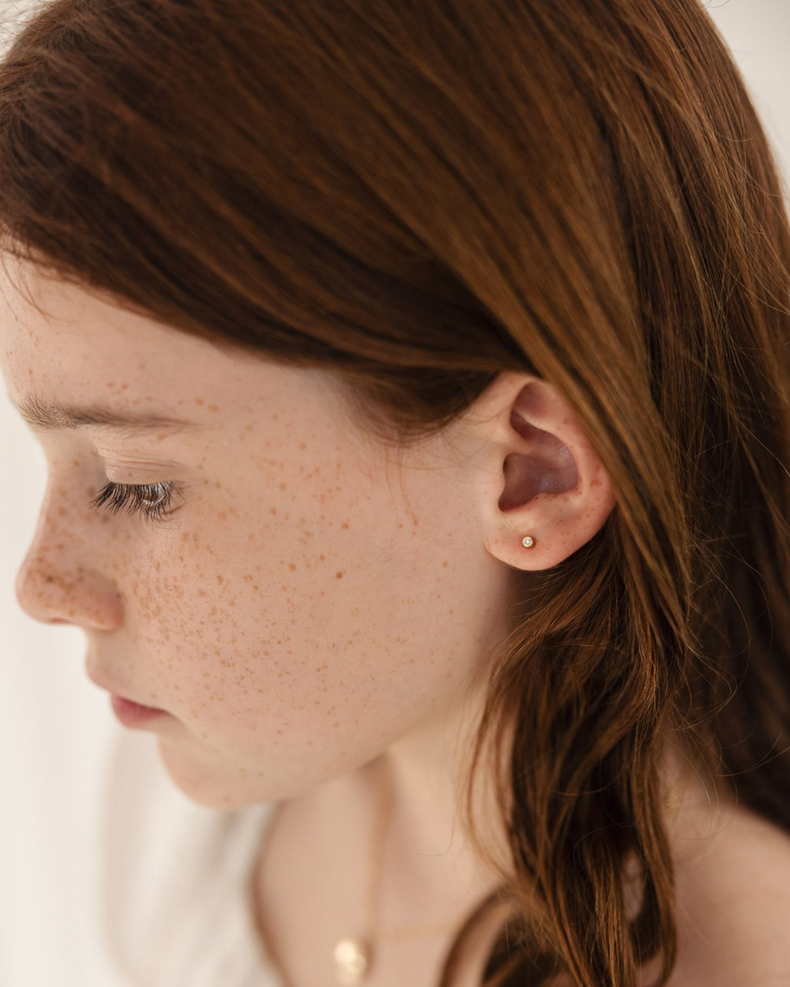 child model wearing the petits cascade studs in yellow gold