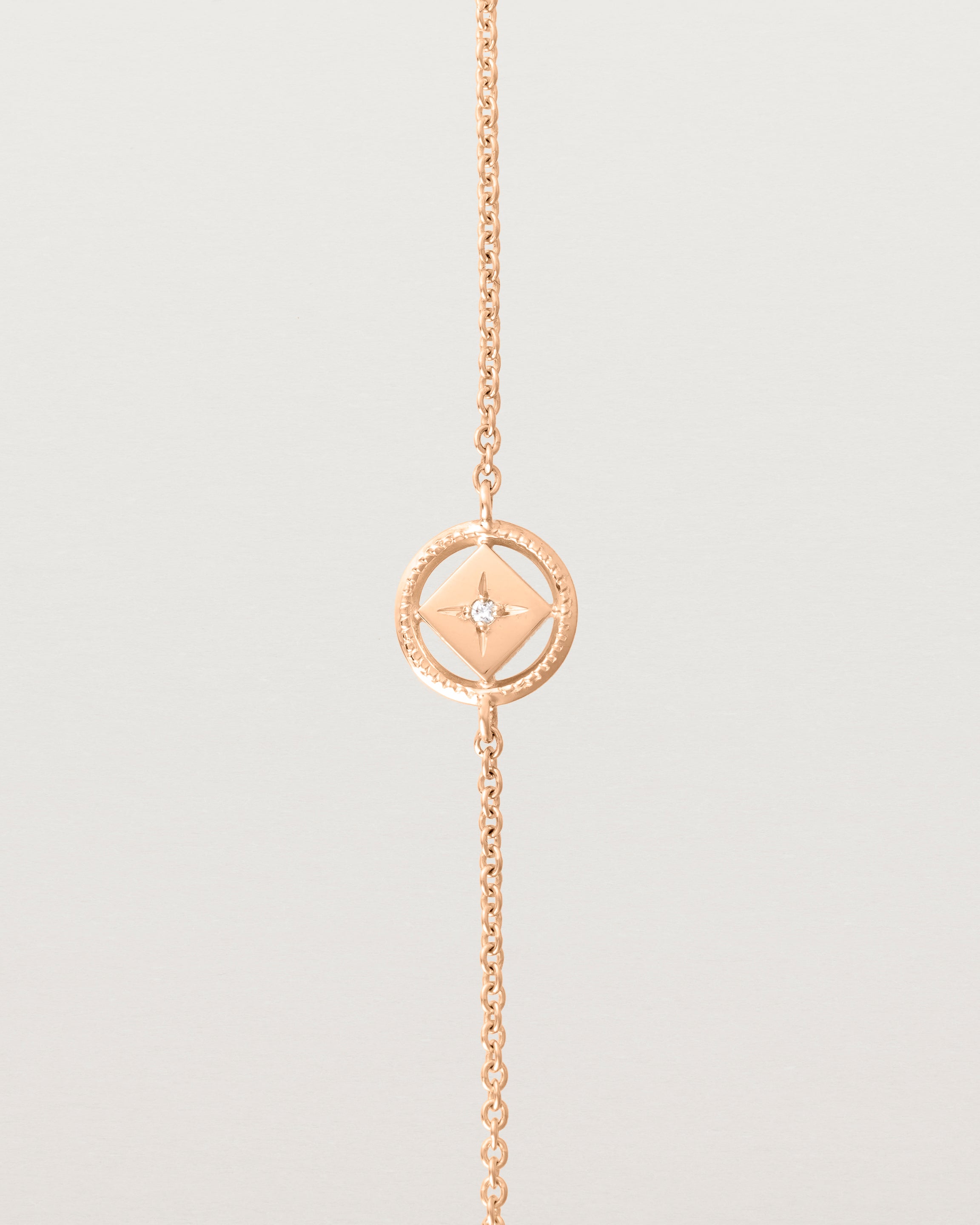 Close up on the feature of the Polaris Bracelet in rose gold, featuring a white diamond. 