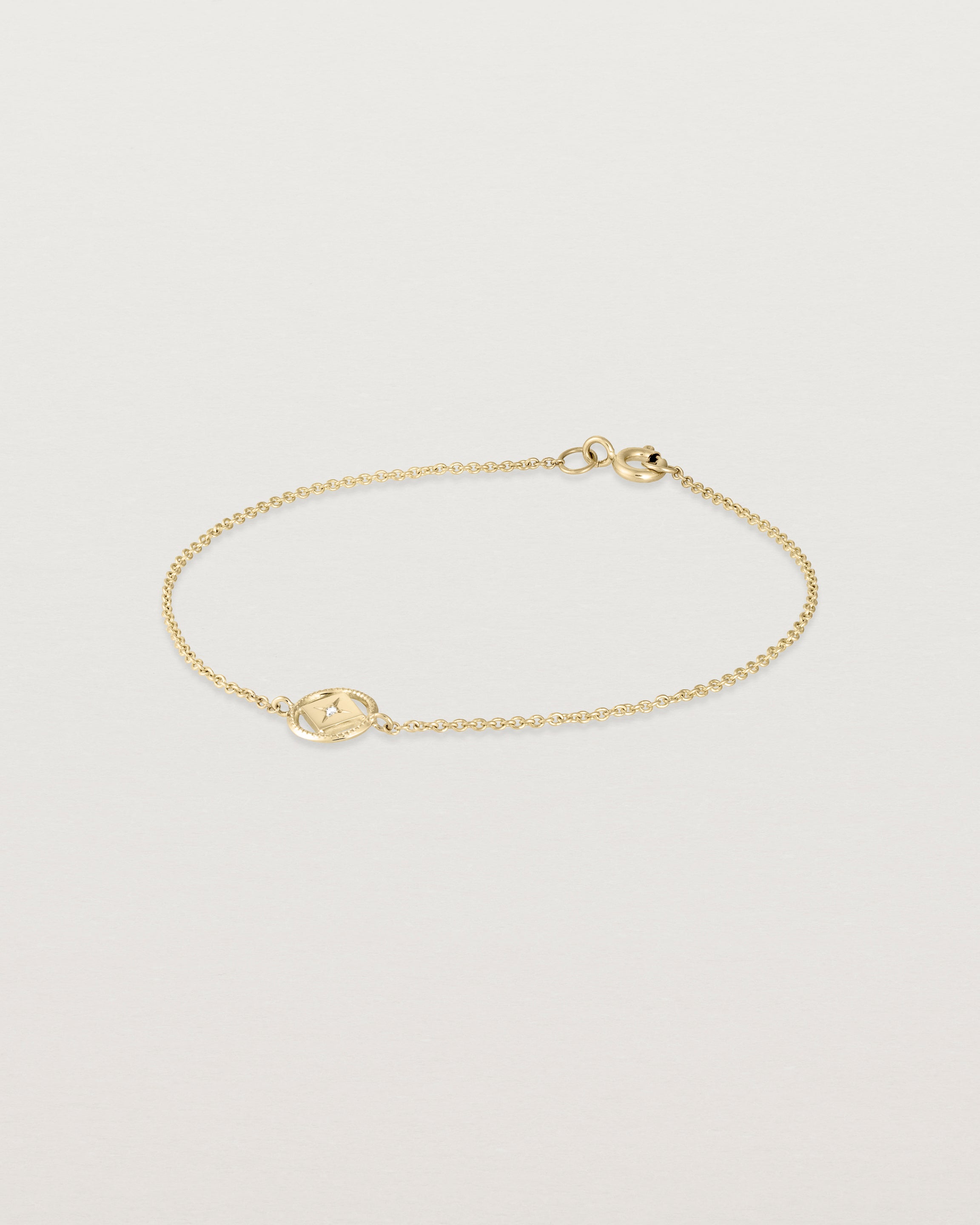 Angled view of the Polaris Bracelet | Birthstone in yellow gold with a white diamond.
