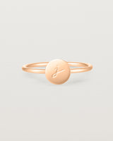 Front view of a rose gold ring featuring a disc with the letter j engraved