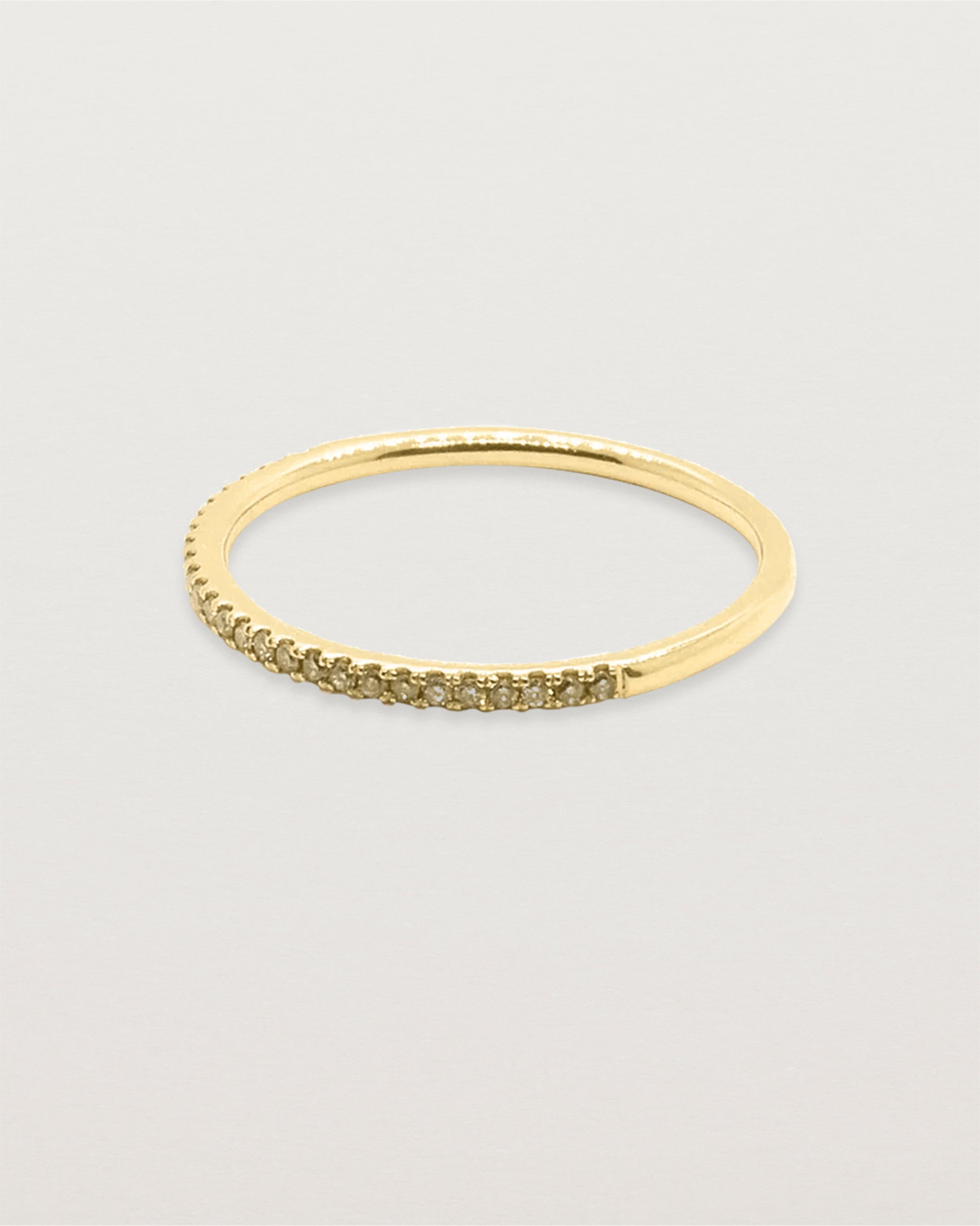 A half band of champagne diamonds set on a yellow gold ring