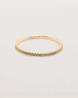 A half band of champagne diamond set on a rose gold band