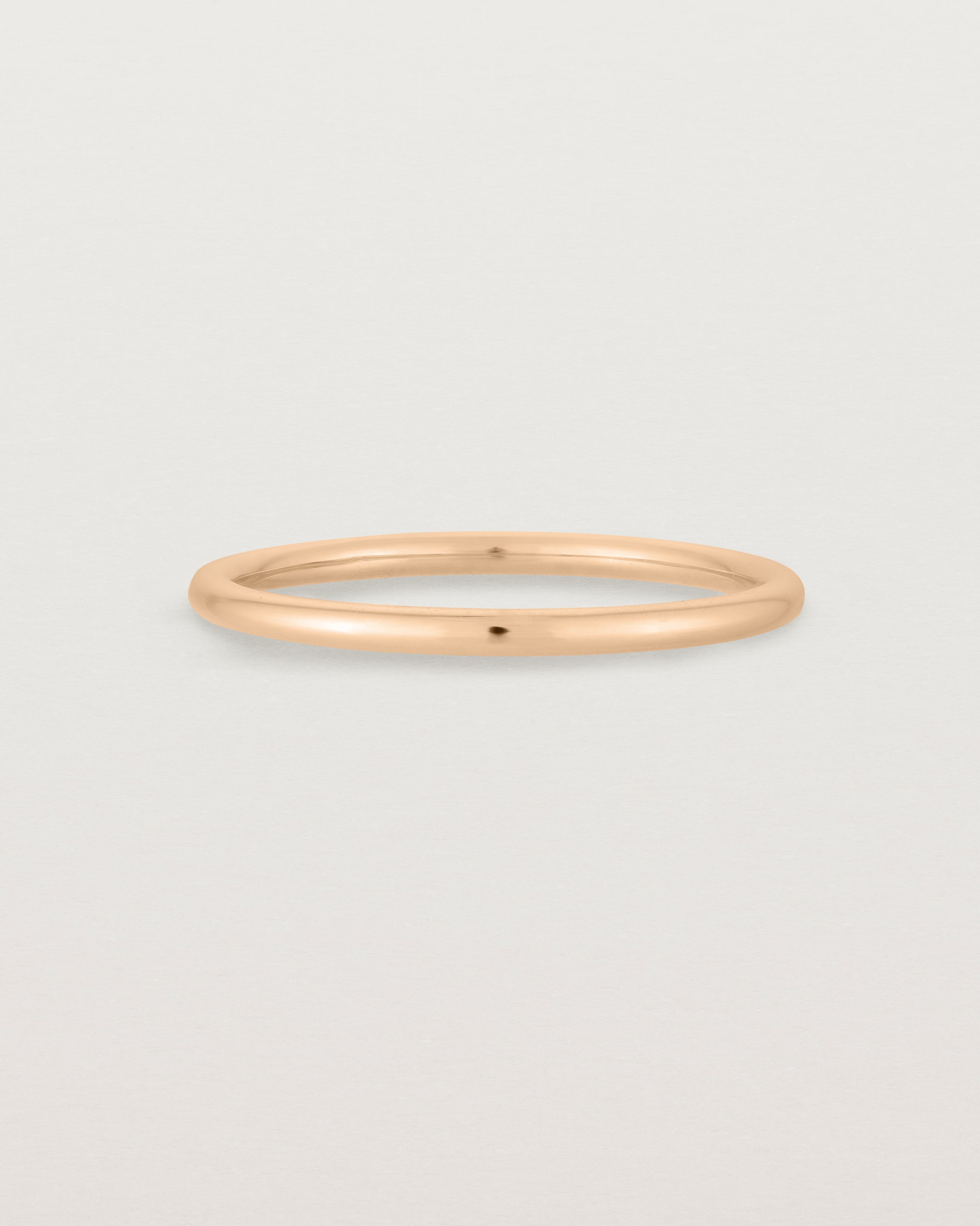 Our fine round wedding band in rose gold