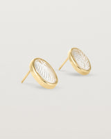 A pair of large oval yellow gold studs featuring carved quartz