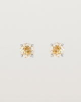 A pair of sterling silver studs featuring a round cut light yellow rutilated quartz stone