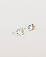 A pair of sterling silver studs featuring a round cut light yellow rutilated quartz stone