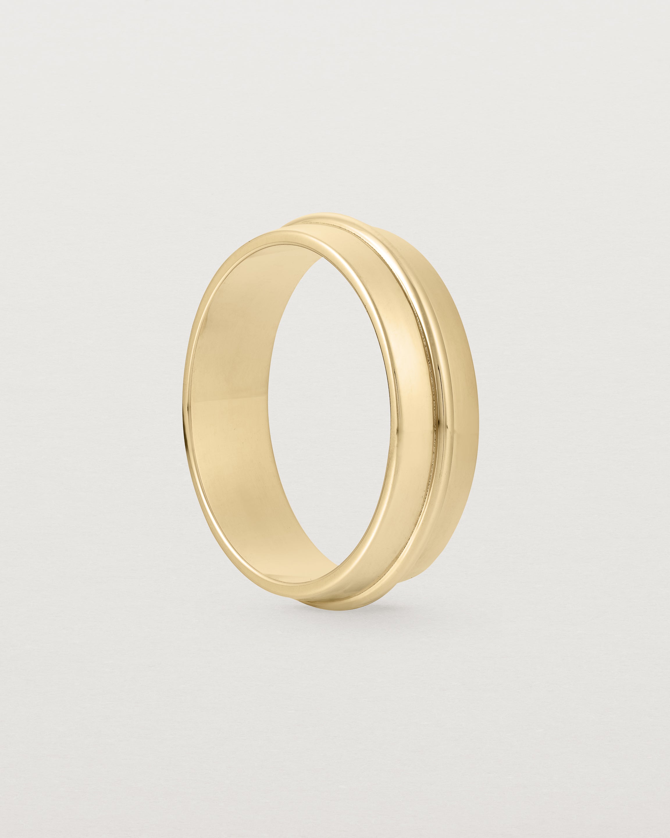 Angled view of the Seam Wedding Ring | 6mm | Yellow  Gold.