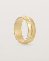 Angled view of the Seam Wedding Ring | 7mm | Yellow Gold.