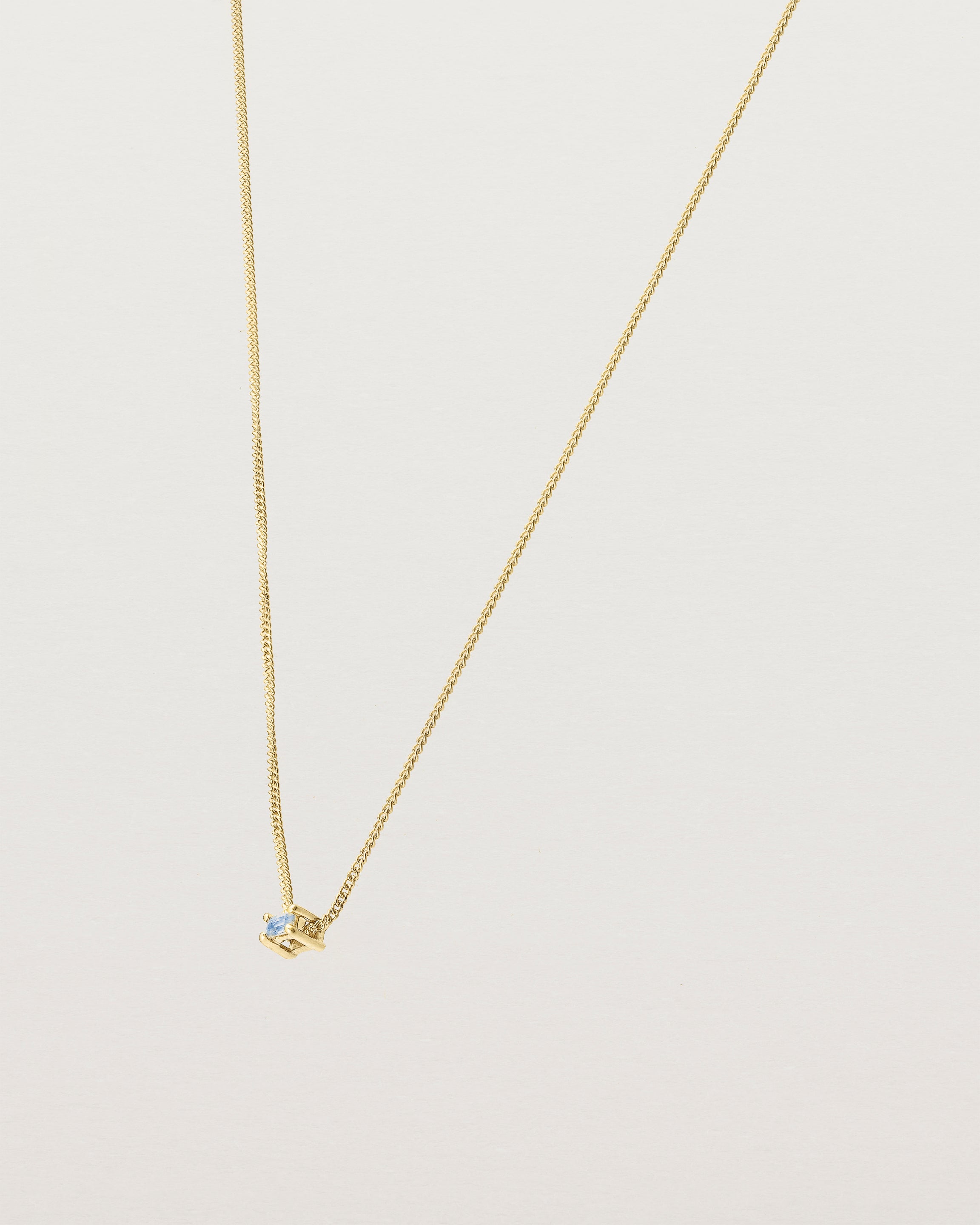 Angled view of the Sena Slider Necklace with Pale Blue Sapphire in yellow gold.