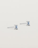 A pair of white gold studs featuring an emerald cut pale blue sapphire