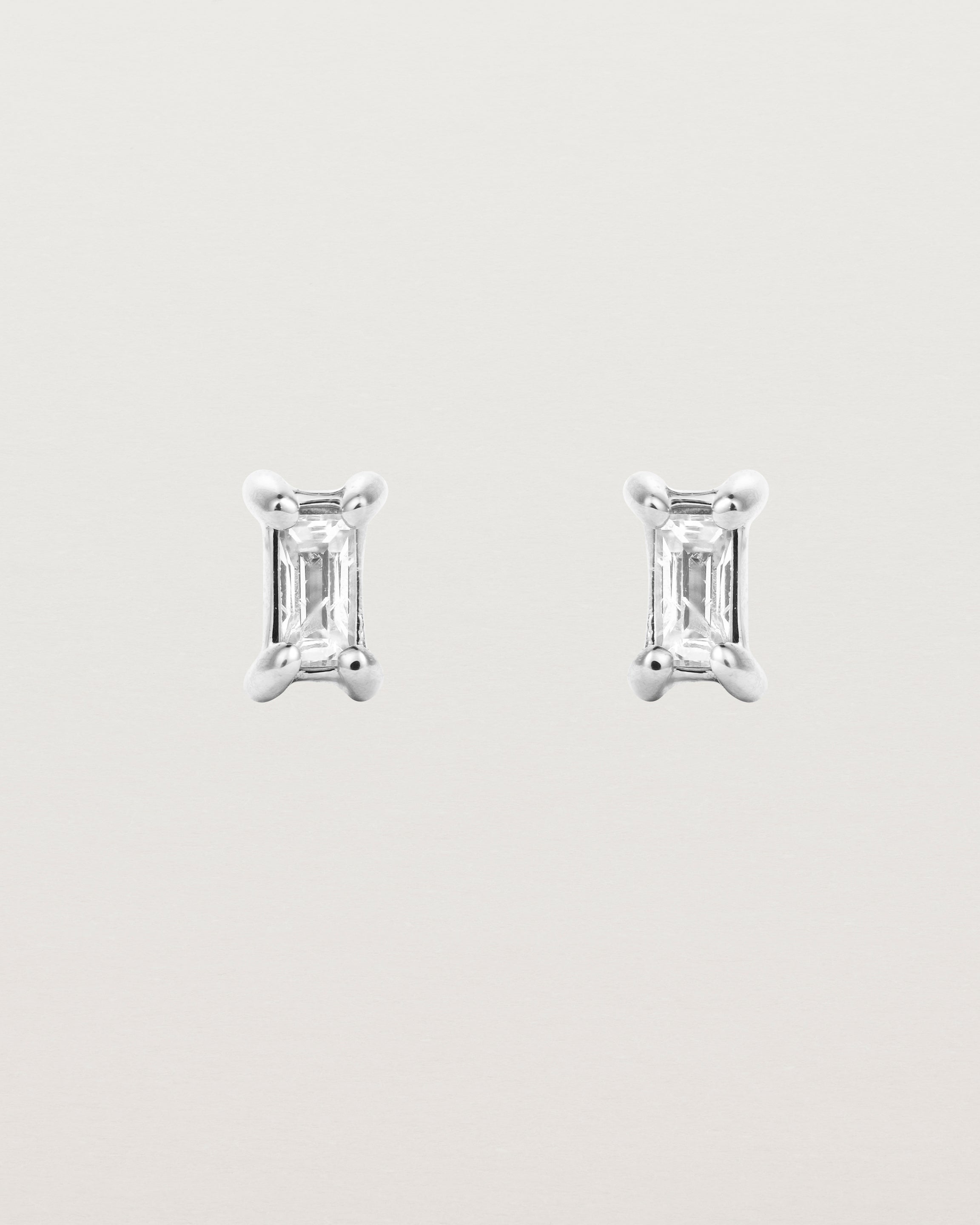 A pair of sterling silver studs featuring an emerald cut white diamond