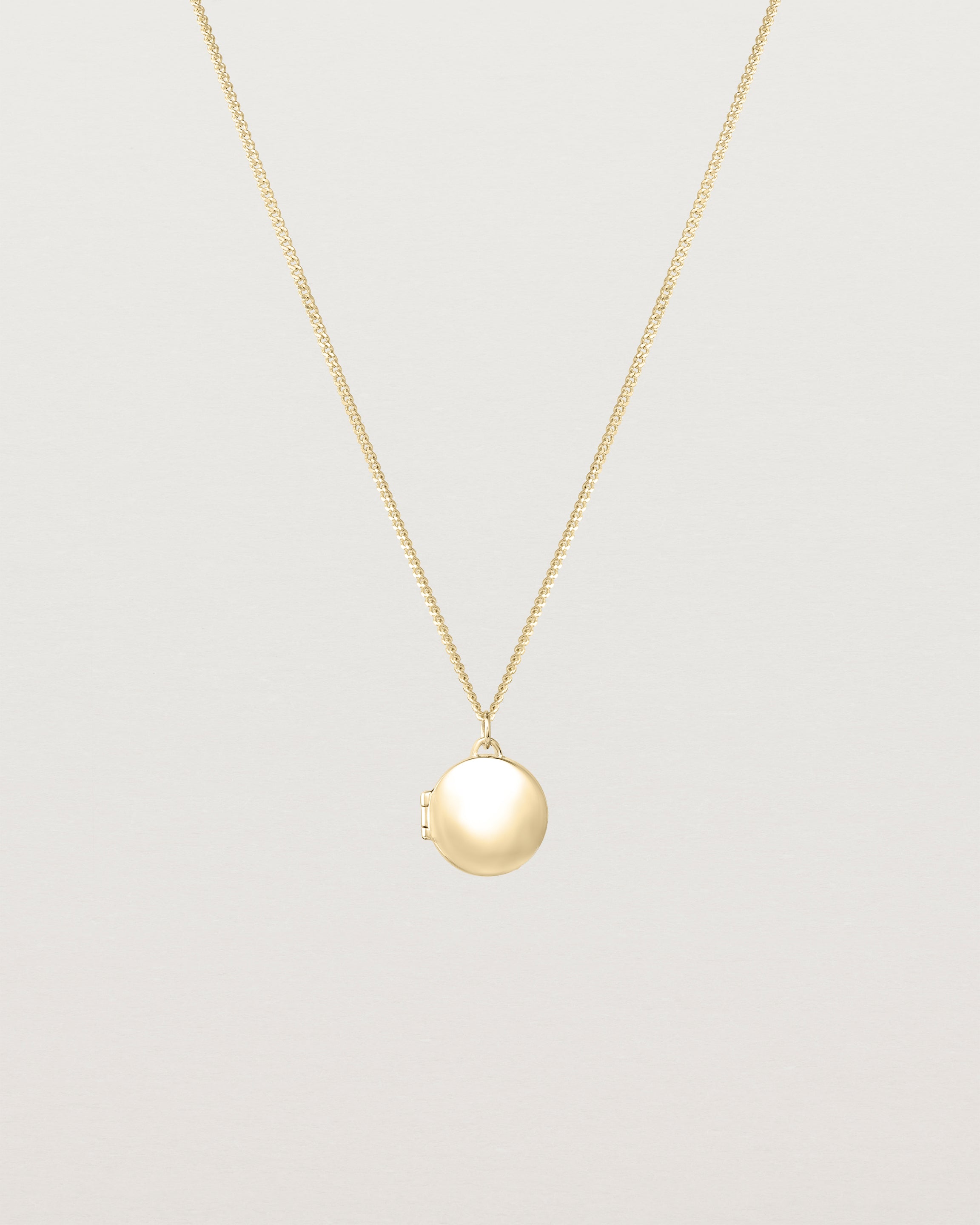 Front view of the Signature Locket in yellow gold.