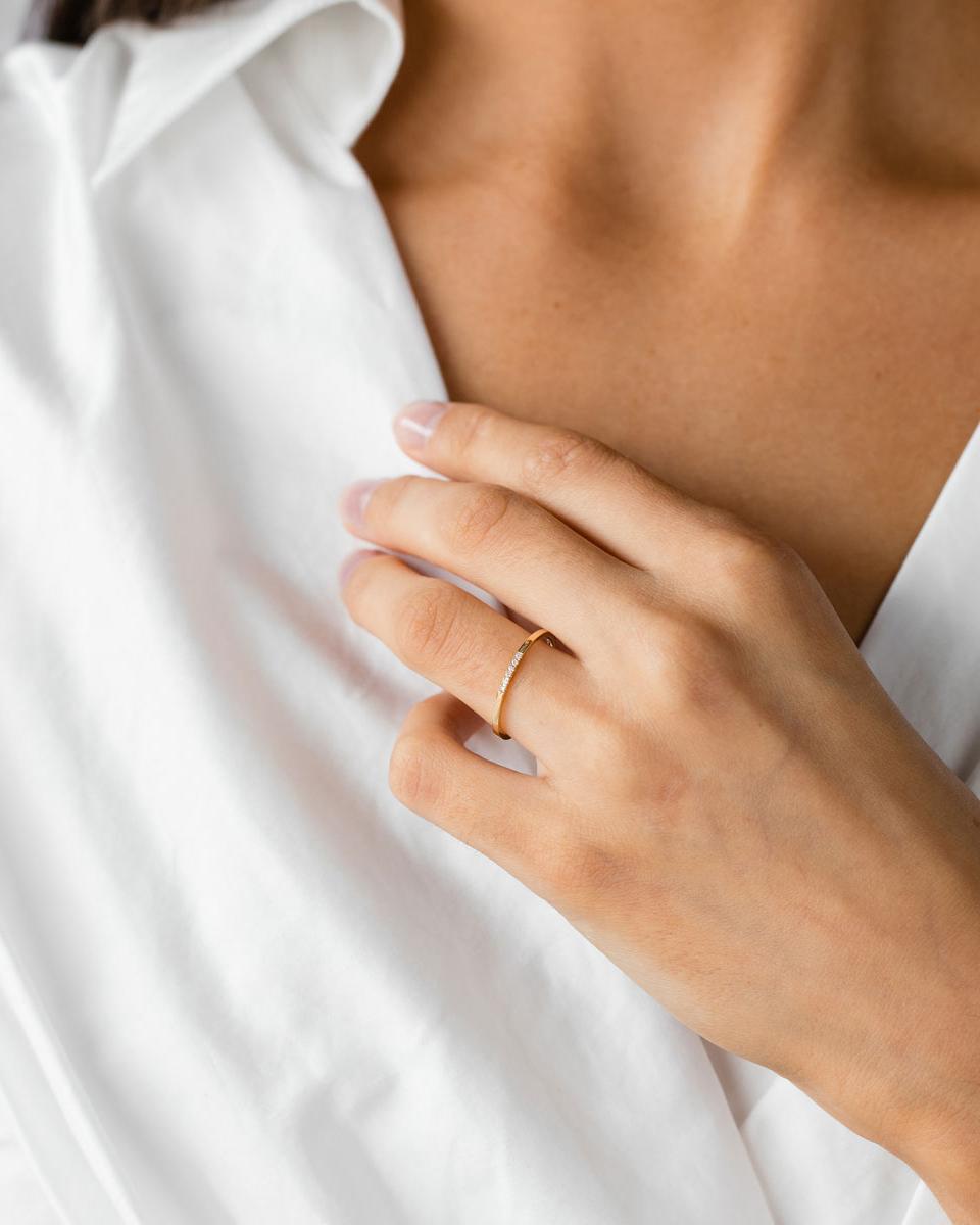 A woman wearing the Six Stone Queenie Ring | Diamonds in Yellow Gold. 