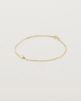 Sonder bracelet in yellow gold showing one charm