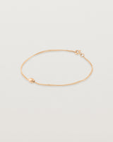 Side view of Sonder bracelet in rose gold showing one charm