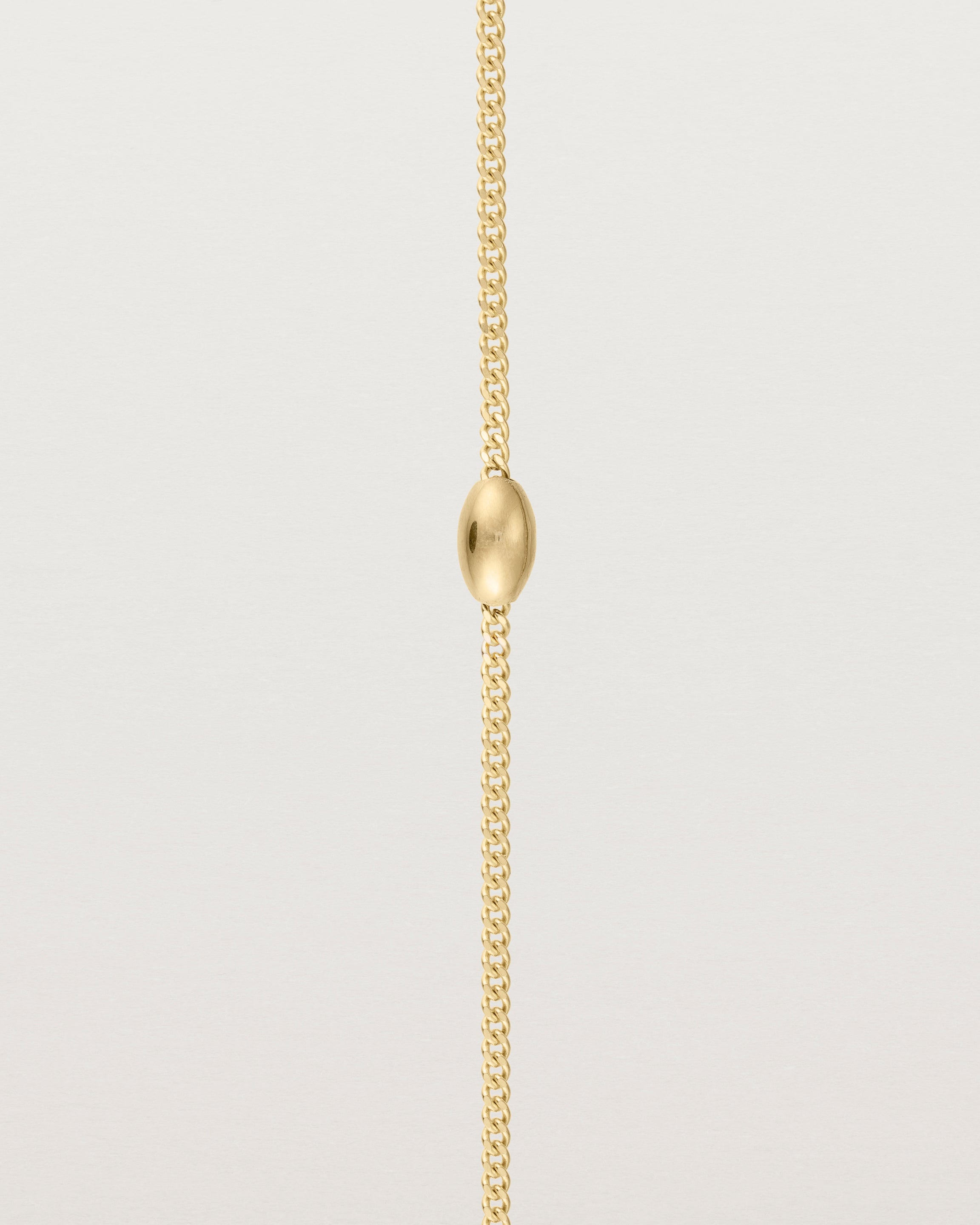 close up of Sonder bracelet in yellow gold showing one charm