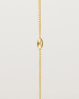 close up of Sonder bracelet in yellow gold showing one charm