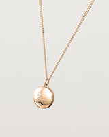 Angled view of the Spotted Orchid Locket in rose gold.