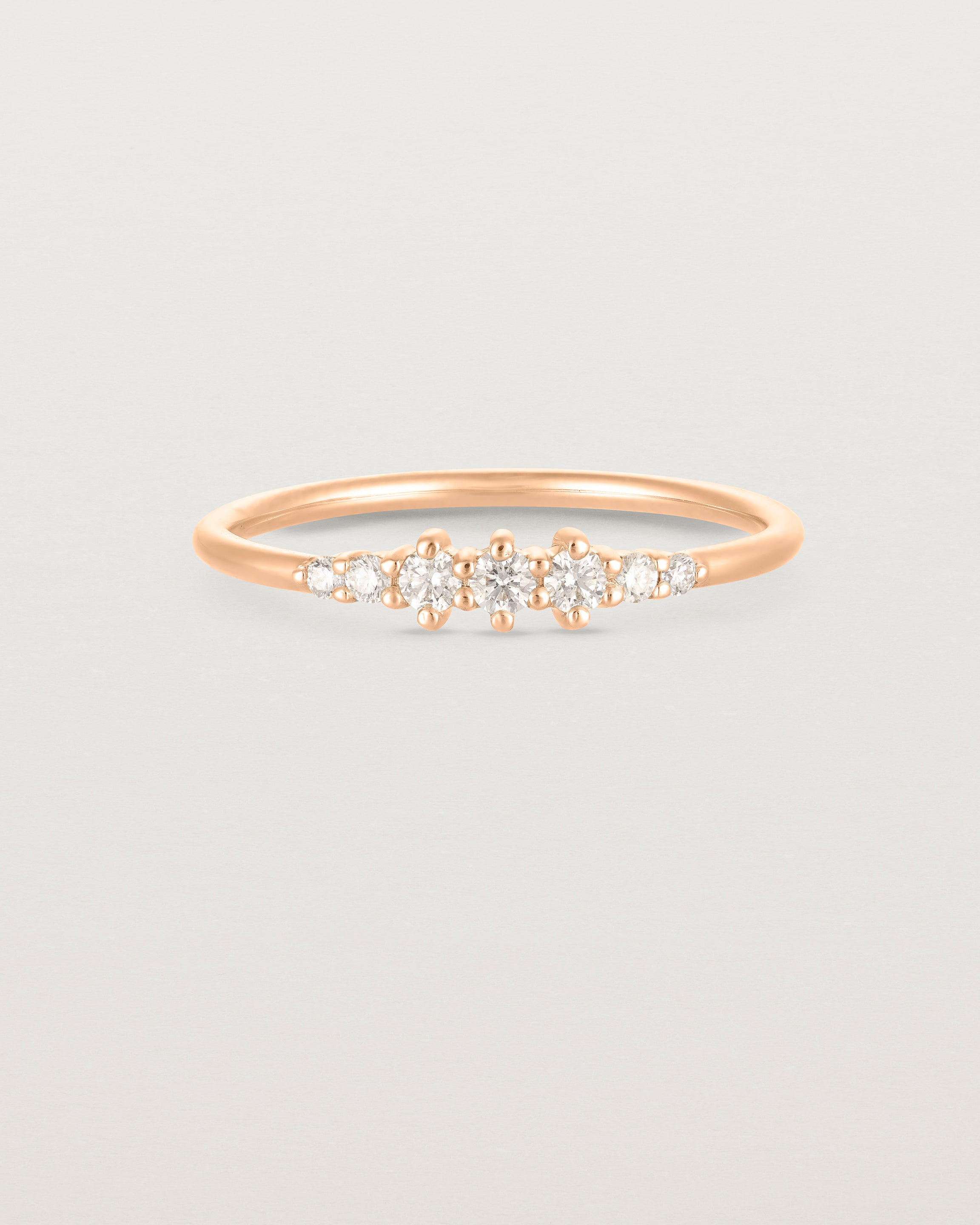 Front facing deep etched image of a rose gold ring with diamonds.