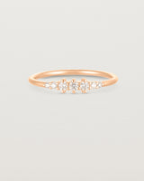 Front facing deep etched image of a rose gold ring with diamonds.