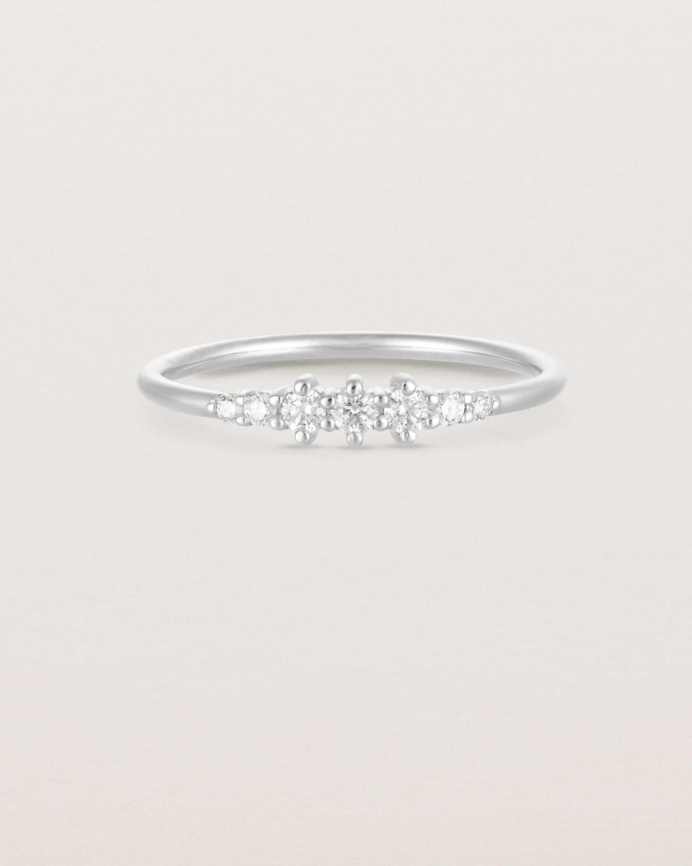 Front facing deep etched image of a white gold ring with diamonds.