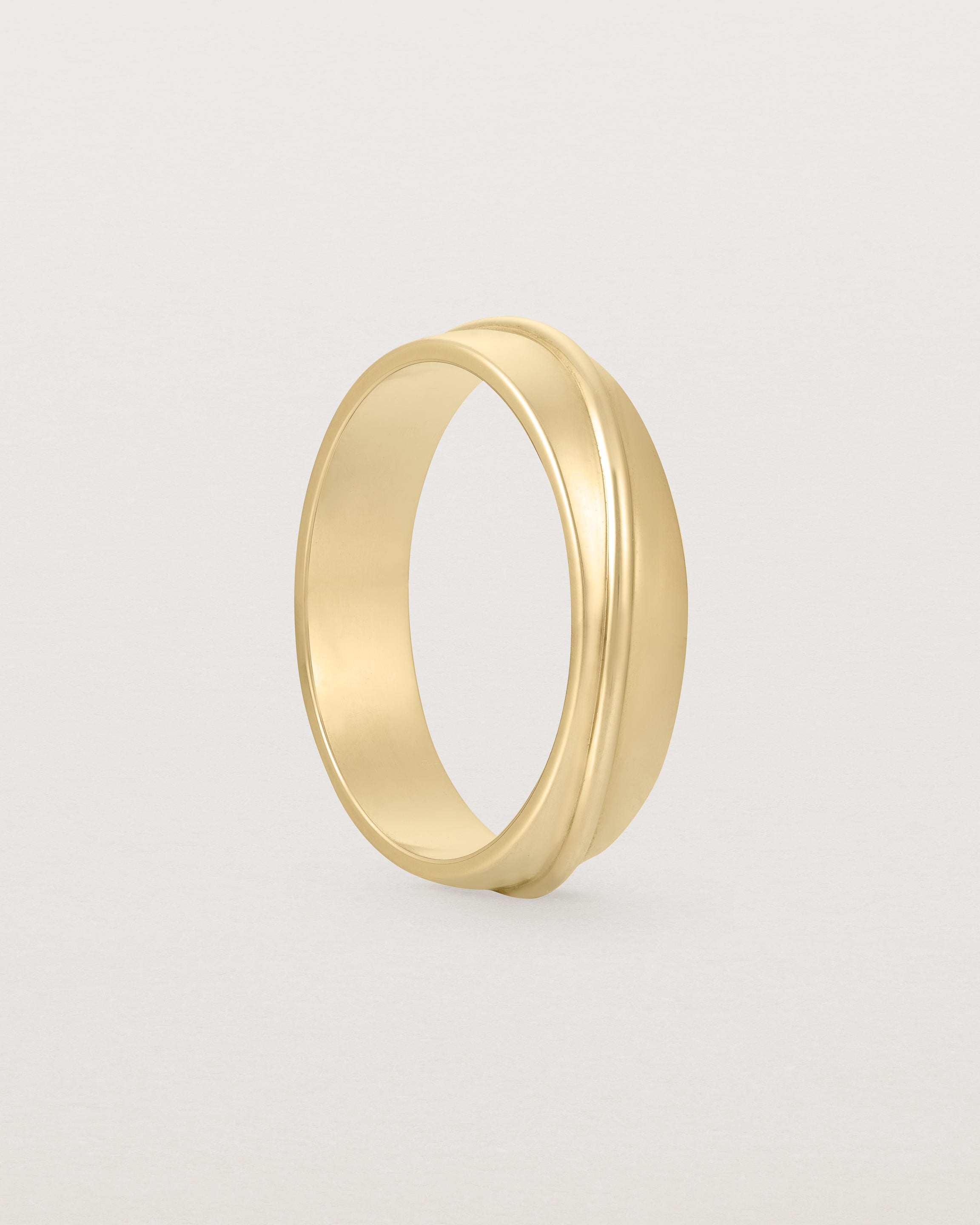 Angled view of the Surge Wedding Ring | 5mm | Yellow Gold.