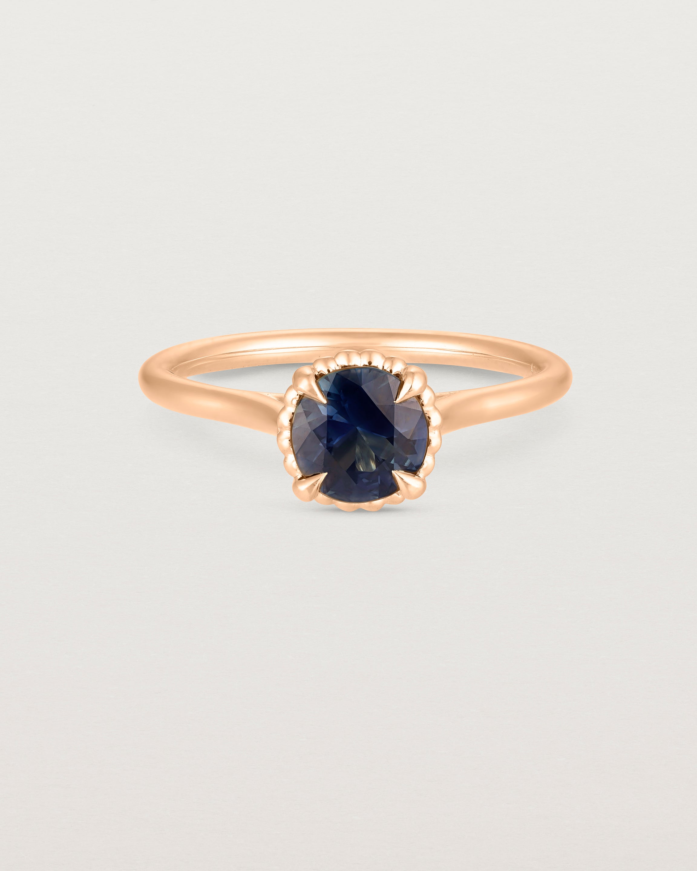 A front view of the Thea Round Solitaire with a deep blue Australian Sapphire in Rose Gold