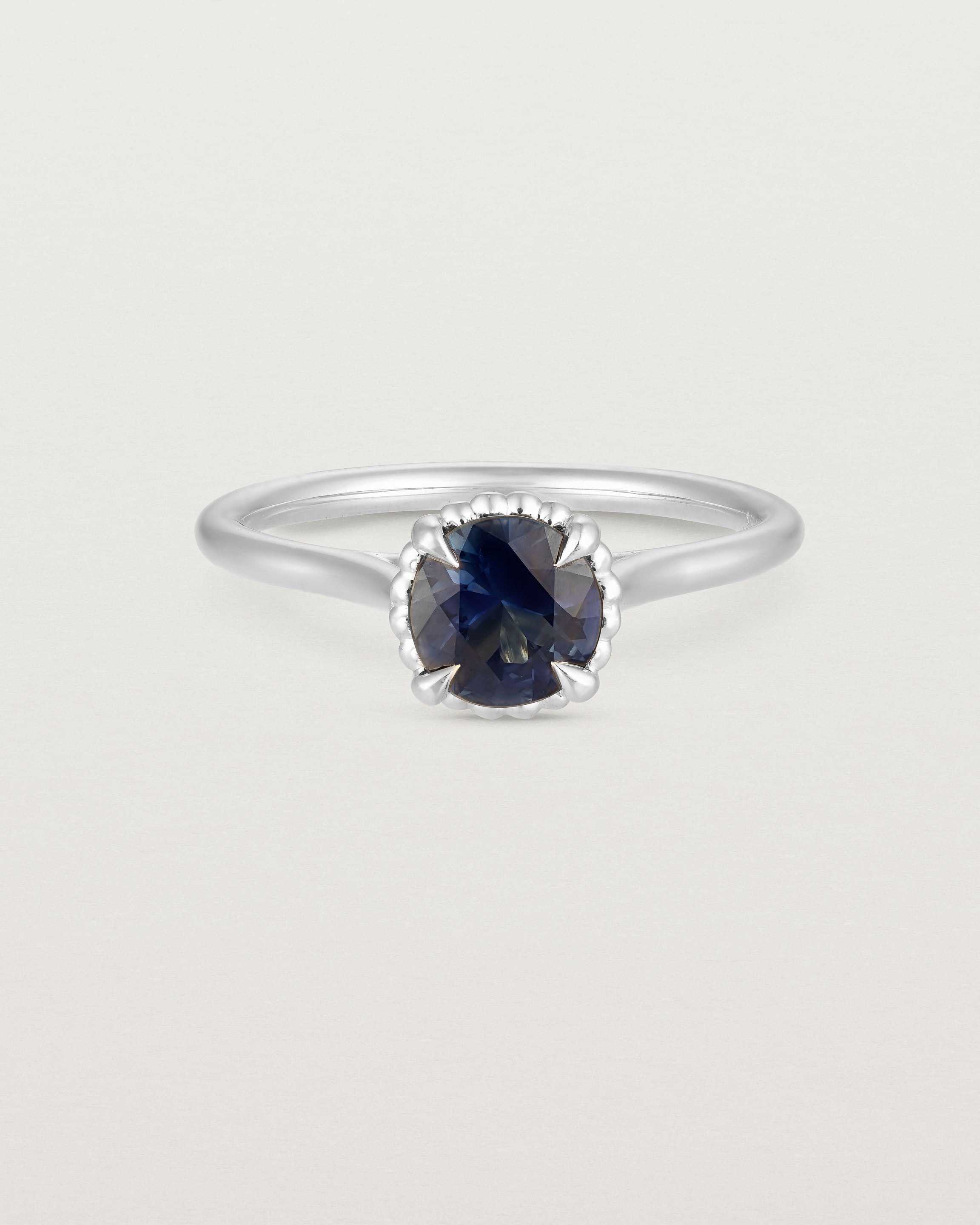 A front view of the Thea Round Solitaire with a deep blue Australian Sapphire in White Gold