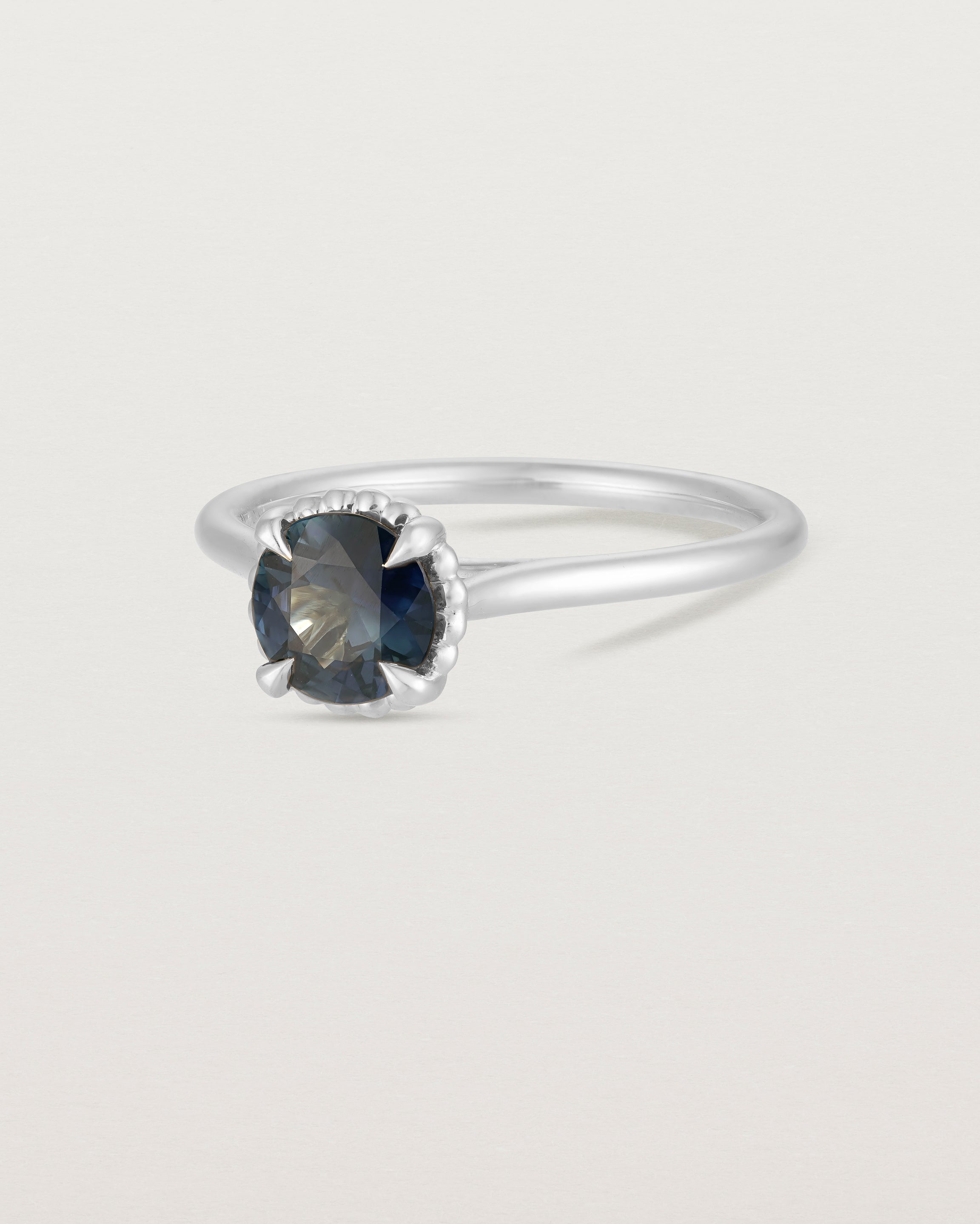 A side view of the Thea Round Solitaire with a deep blue Australian Sapphire in White Gold