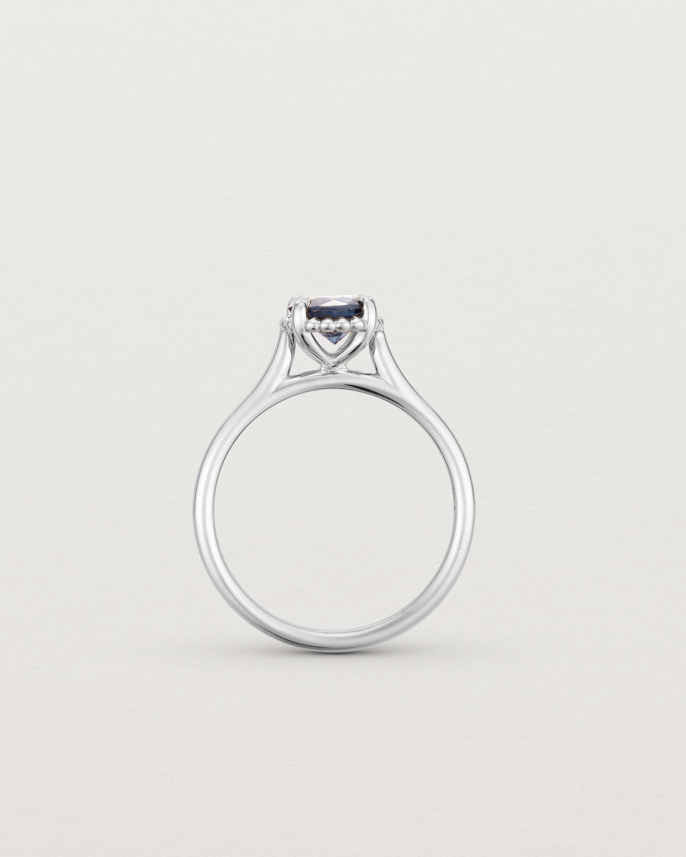 A side profile of the Thea Round Solitaire with a deep blue Australian Sapphire in White Gold