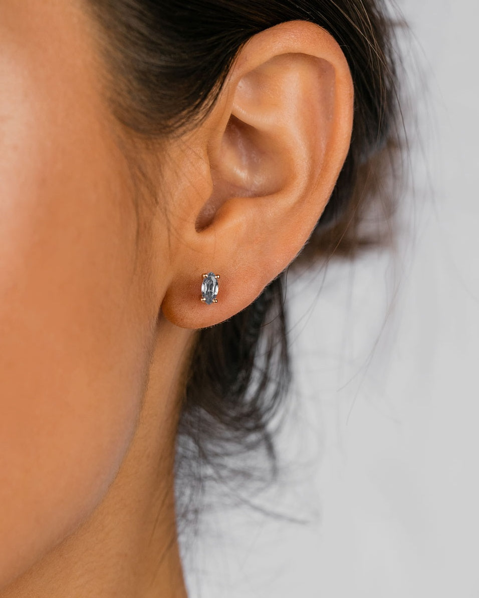 A model wearing the Tiny Marquise Studs | Sapphire | Yellow Gold.