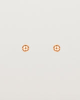 A pair of tiny rose gold studs featuring a round ball